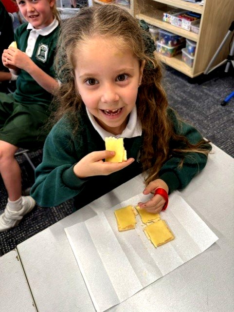 Year 1 learner investigates quarters and wholes using crackers and cheese, building foundational mathematical understanding through practical exploration.